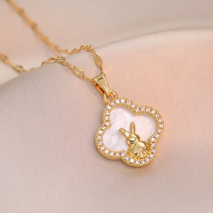 Golden rabbit shell pendant necklace with zircon quatrefoil frame on satin fabric