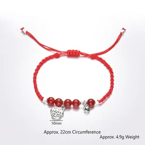 Bracciale rosso in agata intrecciato a mano con campanellino e ciondolo a zampa