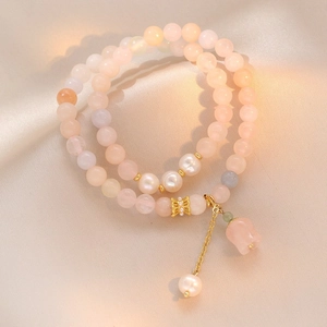 Double-layer Morganite and pearl bracelet with pink flower charm on silk background