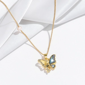 Detail of gold butterfly pendant with iridescent shell and fresh water pearl on silk
