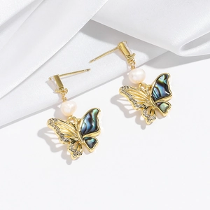 Detail of butterfly earrings with iridescent shell inlay and freshwater pearl accents