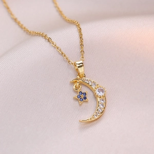 Minimalist gold moon necklace with sparkling white zircons and a tiny blue star pendant