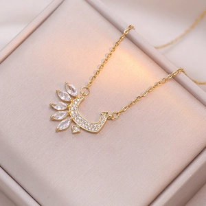 Collier en acier titane doré avec croissant de lune en zircons dans un écrin de luxe
