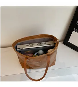 Detailed view of large brown tote bag interior with spacious storage for laptop and books