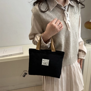 Minimalist black canvas bucket bag with cute bear patch and brown fabric handles