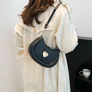 Fashionable black semicircular saddle bag with golden heart buckle shown on model