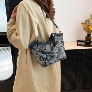 Borsa tote a fiori con bordo ondulato indossata da una donna in cappotto beige