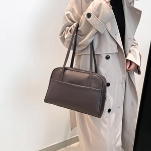 Minimalist dark brown PU leather tote bag worn with a stylish trench coat