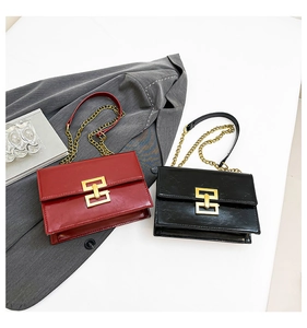 Detailed close-up of red and black leather crossbody bags with gold metal clasps