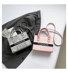 Dettaglio di eleganti borse tote con trama ricamata e tracolle rimovibili in colori mix