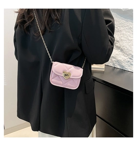 Détail du sac bandoulière en cuir matelassé rose avec boucle cœur dorée et chaîne