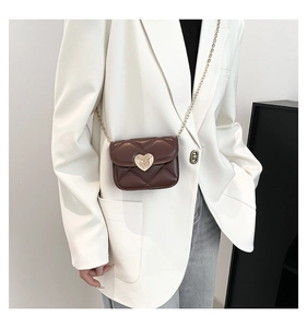 Détail d'un mini sac bandoulière marron matelassé avec fermoir cœur doré et chaîne