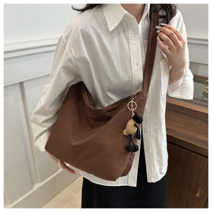 Brown large capacity crossbody bag featuring a cute sheep plush charm on the strap