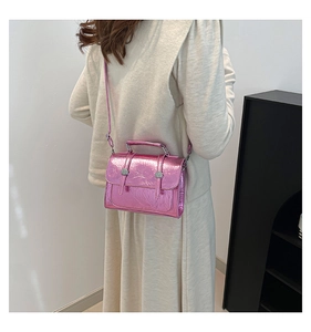 Model wearing the metallic pink crossbody bag showing its compact size and glossy texture