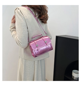 Détail d'un sac à main rose métallisé brillant avec texture froissée et boucles argentées