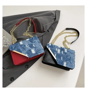 Detailansicht der Denim-Umhängetasche mit Distressed-Finish und goldener Kette
