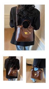 Detail view of vintage brown patent leather tote bag with metallic triangle logo and strap