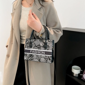Elegante borsa tote ricamata in bianco e nero con logo FASHION e manici corti