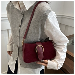 Gros plan du sac à bandoulière bordeaux vintage avec finition mate et boucle dorée