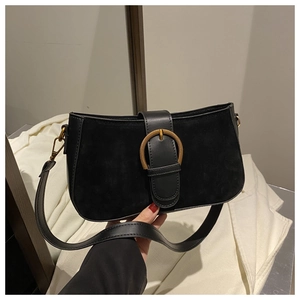 Close-up of black matte leather shoulder bag with a large gold horseshoe metal buckle