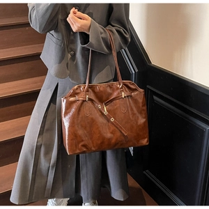 Close-up of vintage brown tote bag with retro oil wax leather texture and metal buckle