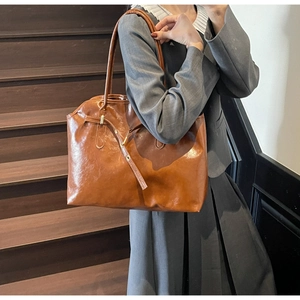 Macro shot of minimalist brown leather tote bag with elegant gold metal buckles
