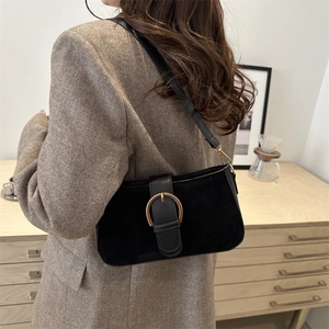Classic black suede and leather underarm bag with vintage gold buckle on model