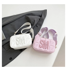 Detail van witte en roze gewatteerde crossbodytassen met SM-logo-reliëf en brede riem