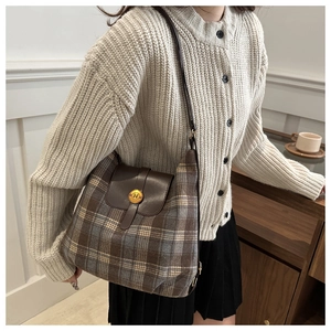 Detail of checkered plaid shoulder bag featuring premium brown leather and gold N buckle