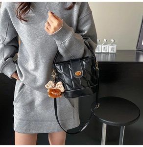 Détail du sac seau noir à carreaux avec fermoir doré et breloque ours mignon