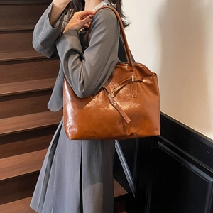 Brown glossy leather tote bag for women featuring a spacious design and gold hardware
