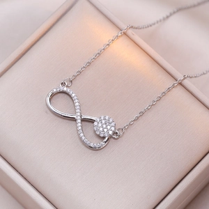 Infinity symbol necklace with sparkling zircons on elegant champagne satin in gift box