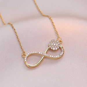 Infinity circle pendant necklace in gold finish with micro-pave crystals on pink silk