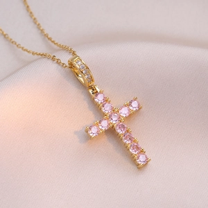 Collier croix en or élégant avec pierres de zircon rose sur fond en soie douce
