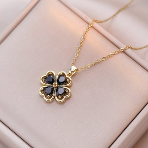 Détail d'un pendentif trèfle doré avec zircons noirs en forme de cœur sur une chaîne