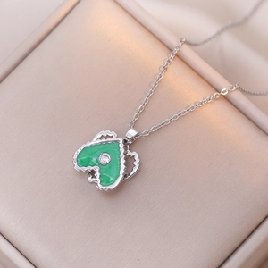 Silver heart necklace with green enamel pendant and zircon on golden display stand