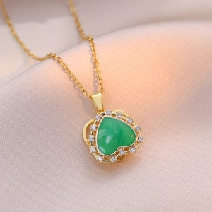 Detailed view of rotating emerald heart pendant with white zircon halo on gold necklace