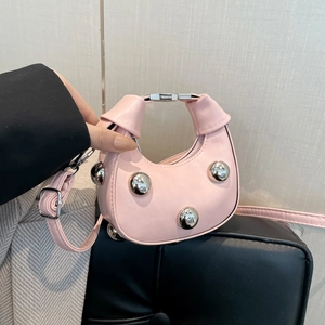 Pink crescent mini handbag with silver studs and knotted handle for crossbody or shoulder wear