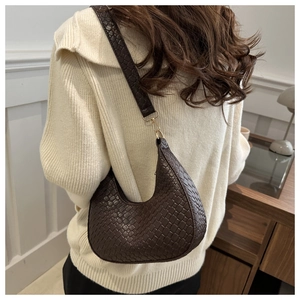Detail of dark brown woven hobo bag showing the intricate texture and gold hardware