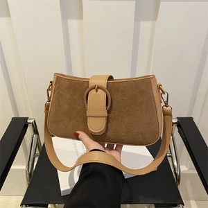 Retro brown suede shoulder bag with leather trim and round buckle in a minimalist design