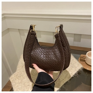 Detail of dark brown woven leather crescent bag with gold hook and Italian style