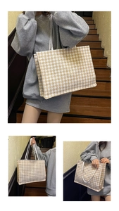 Detail view of yellow houndstooth tote bag featuring woven fabric and slim white shoulder straps