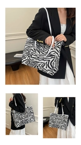 Close-up of zebra pattern tote bag showing black and white texture and slim strap details