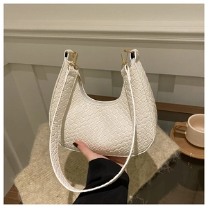 Detail of white crescent hobo bag with crocodile embossed texture and gold hardware