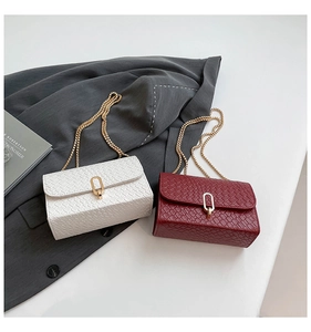 Detail of woven texture leather crossbody bag with elegant golden oval twist lock