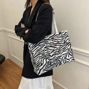 Large zebra print tote bag in canvas fabric worn by model for office commuting style