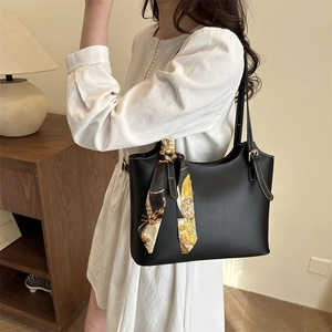 Retro black leather bucket bag with decorative printed scarf and white contrast stitching