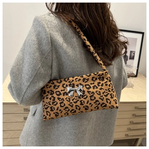 Detail of trendy leopard print underarm bag featuring a silver metal butterfly buckle