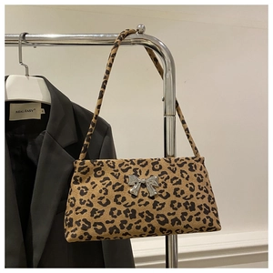 Detail of leopard print underarm bag featuring a silver metal bow buckle on a hanger