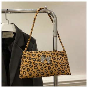 Close-up of leopard print shoulder bag featuring a metallic silver butterfly decoration